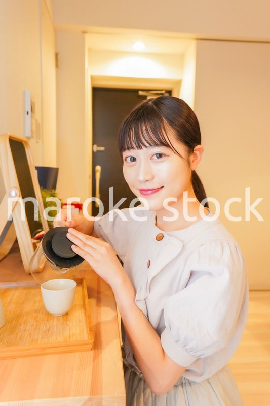 お茶を入れる若い女性