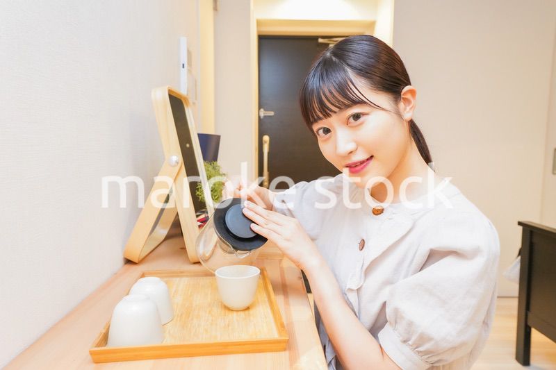 お茶を入れる若い女性