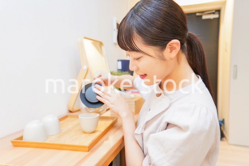 お茶を入れる若い女性