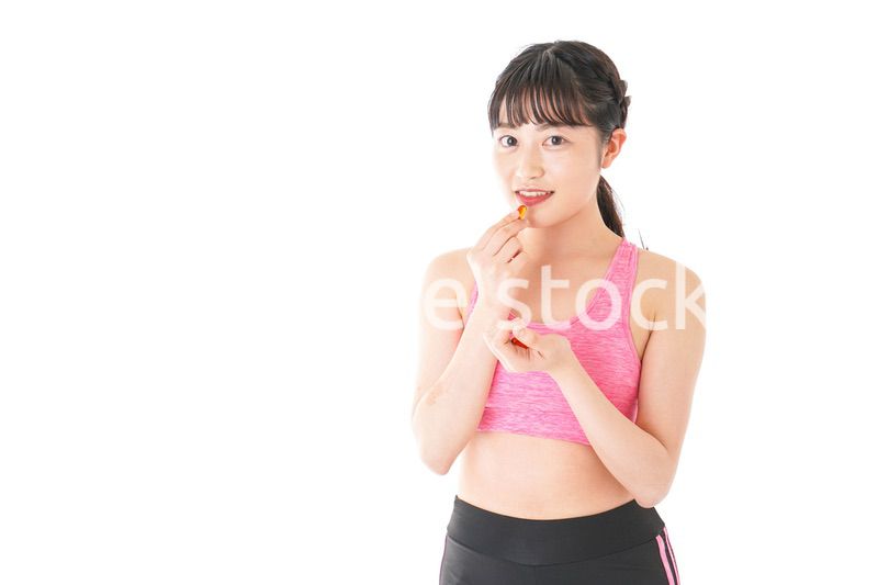 薬・サプリメントを服用する若い女性