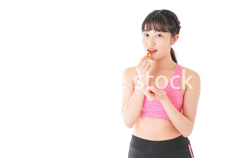 薬・サプリメントを服用する若い女性