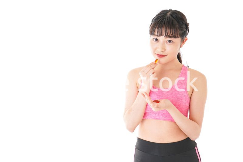薬・サプリメントを服用する若い女性