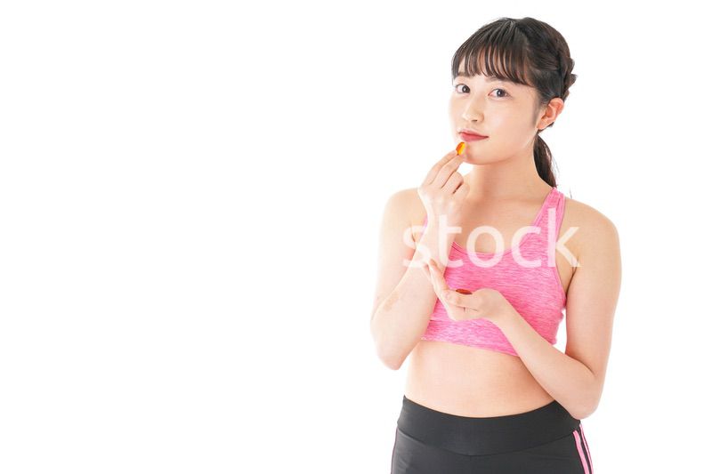 薬・サプリメントを服用する若い女性