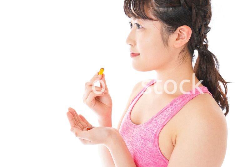 薬・サプリメントを服用する若い女性
