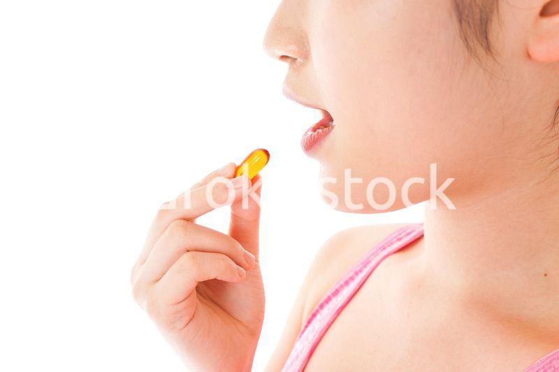 薬・サプリメントを服用する若い女性