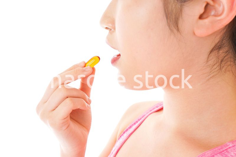 薬・サプリメントを服用する若い女性