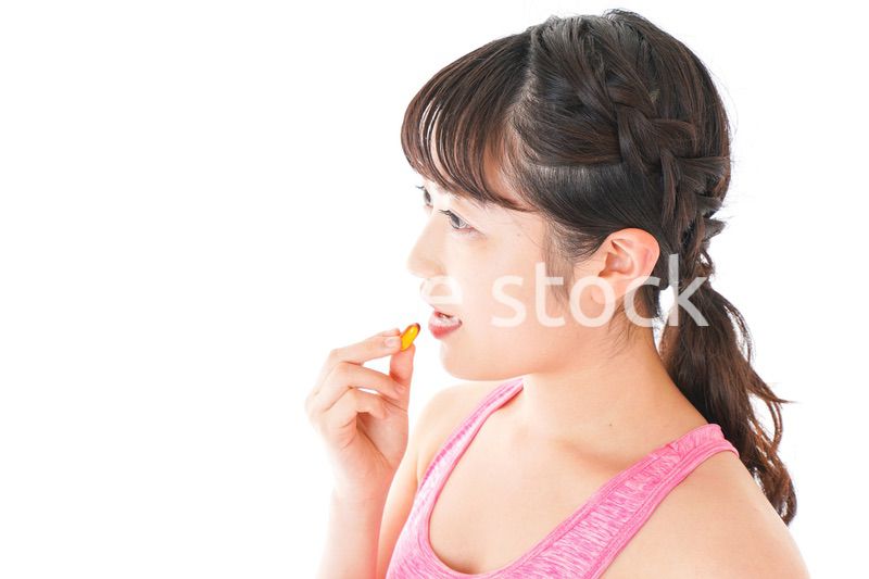 薬・サプリメントを服用する若い女性
