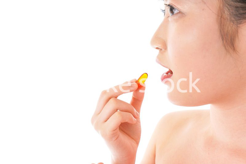 薬・サプリメントを服用する若い女性