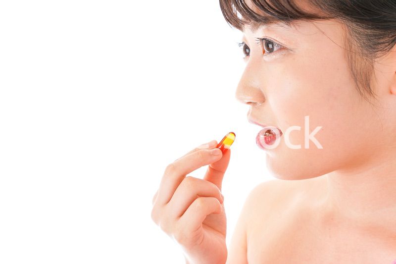 薬・サプリメントを服用する若い女性