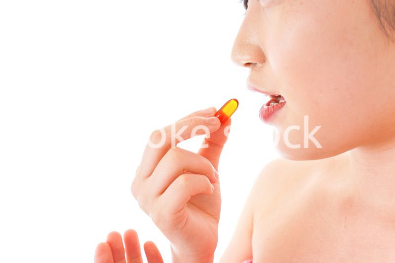 薬・サプリメントを服用する若い女性