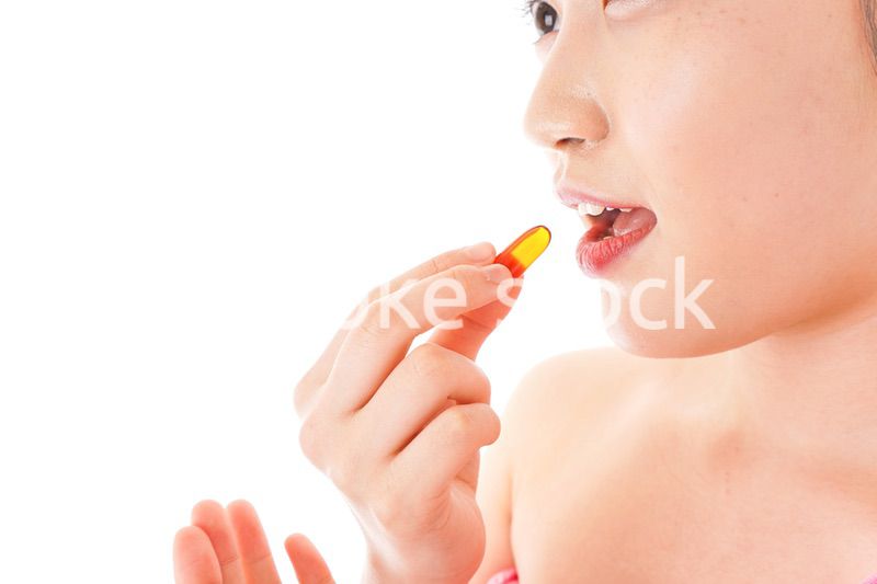 薬・サプリメントを服用する若い女性