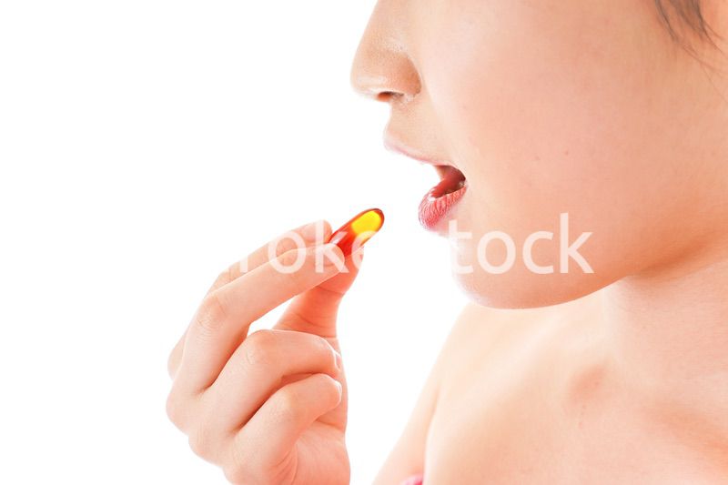 薬・サプリメントを服用する若い女性