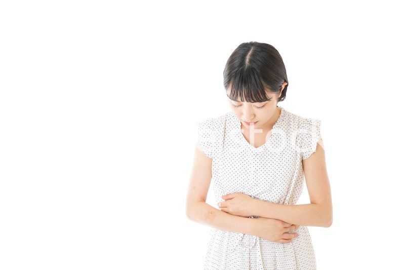 腹痛に苦しむ若い女性