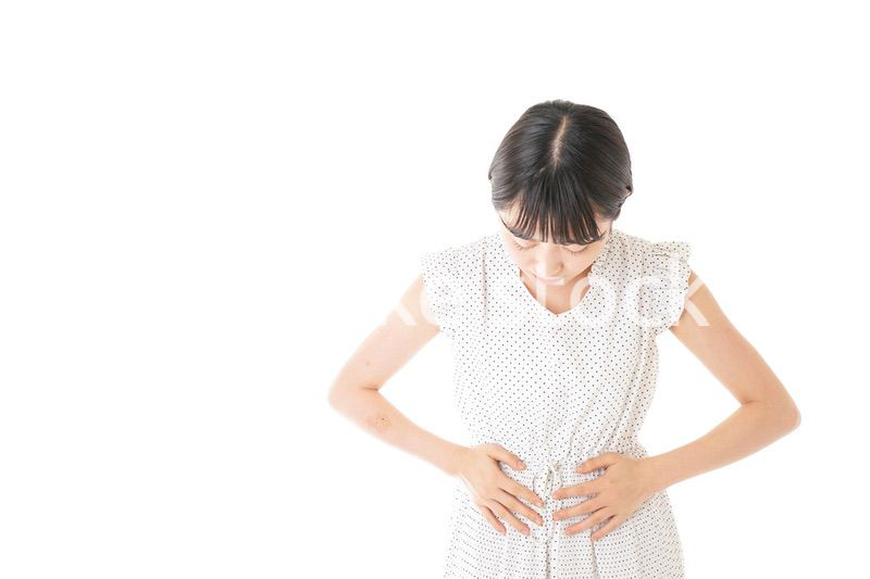 腹痛に苦しむ若い女性