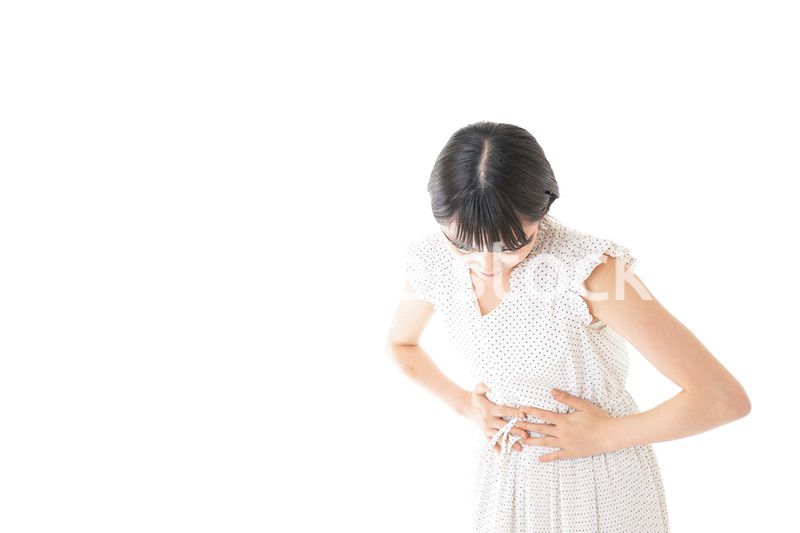 腹痛に苦しむ若い女性
