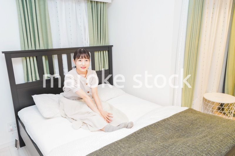 ベッドでリラックスをする若い女性