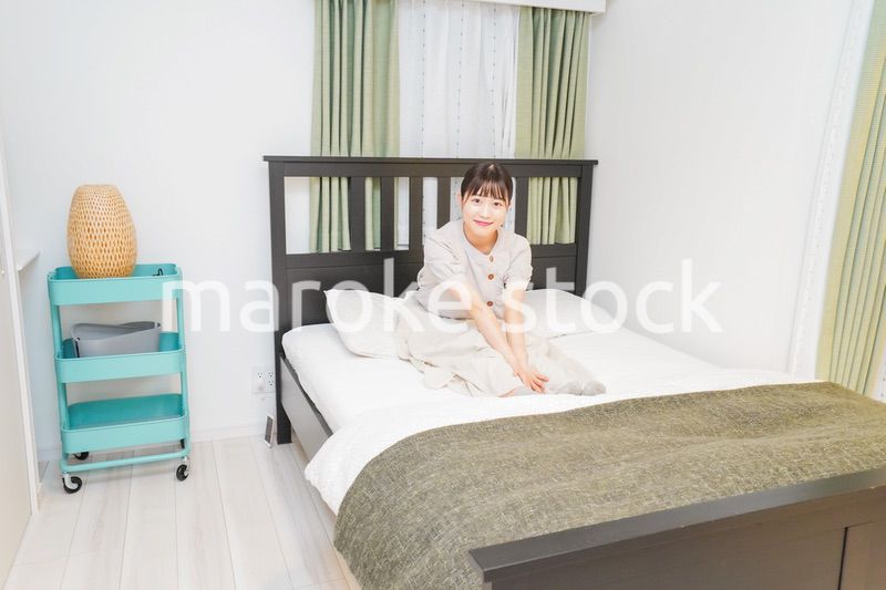 ベッドでリラックスをする若い女性