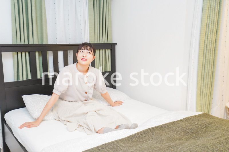 ベッドでリラックスをする若い女性