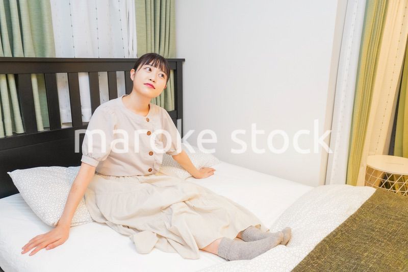 ベッドでリラックスをする若い女性