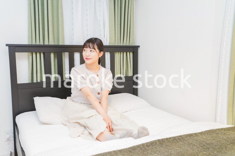 ベッドでリラックスをする若い女性