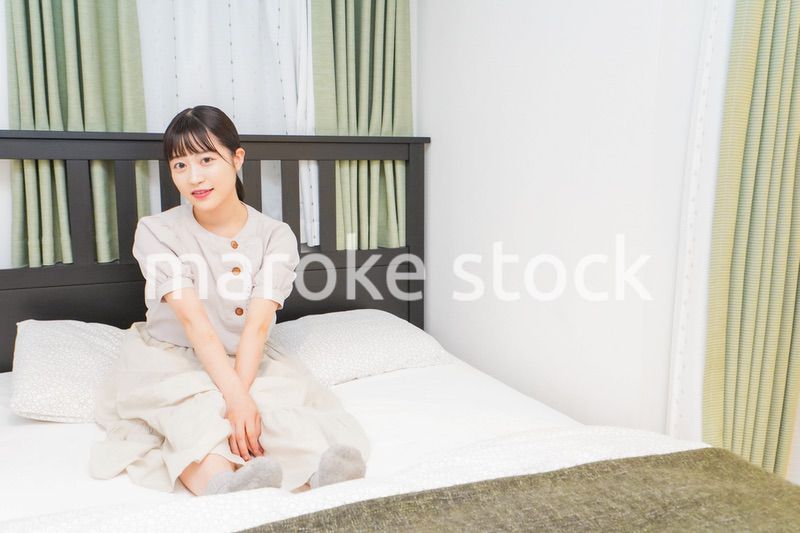 ベッドでリラックスをする若い女性