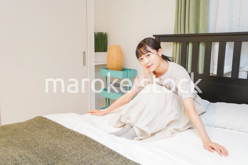 ベッドでリラックスをする若い女性