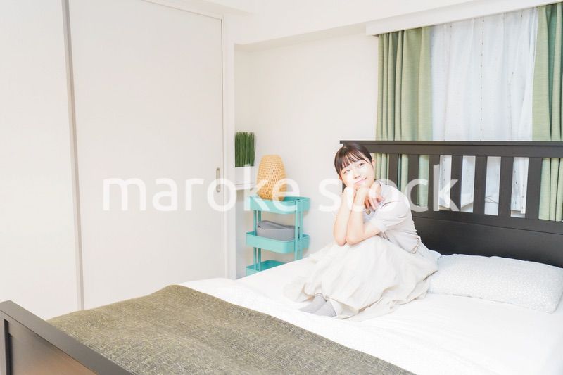 ベッドでリラックスをする若い女性