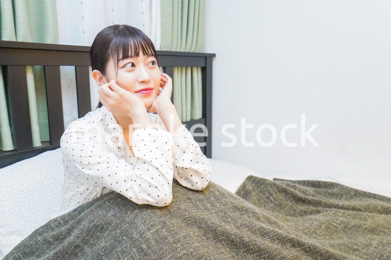 ベッドでリラックスをする若い女性