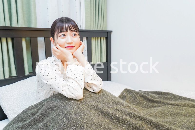 ベッドでリラックスをする若い女性