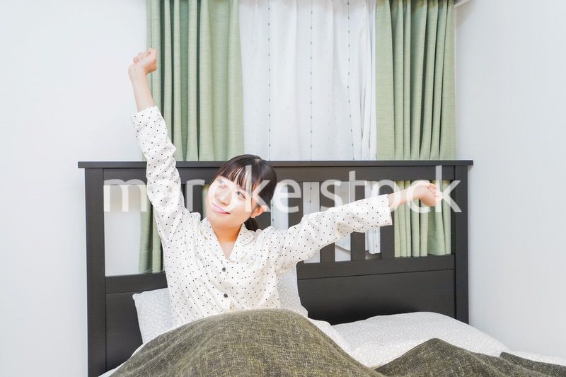 ベッドでリラックスをする若い女性