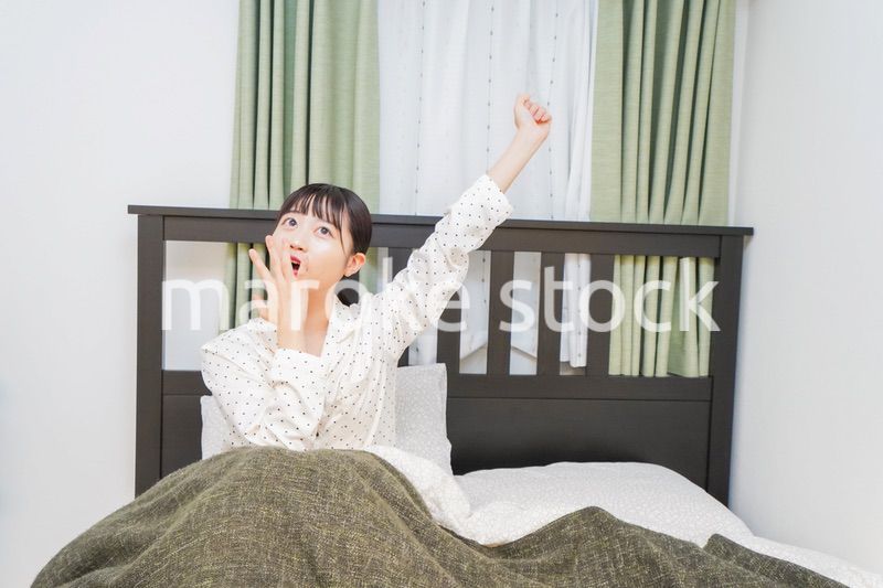 ベッドでリラックスをする若い女性