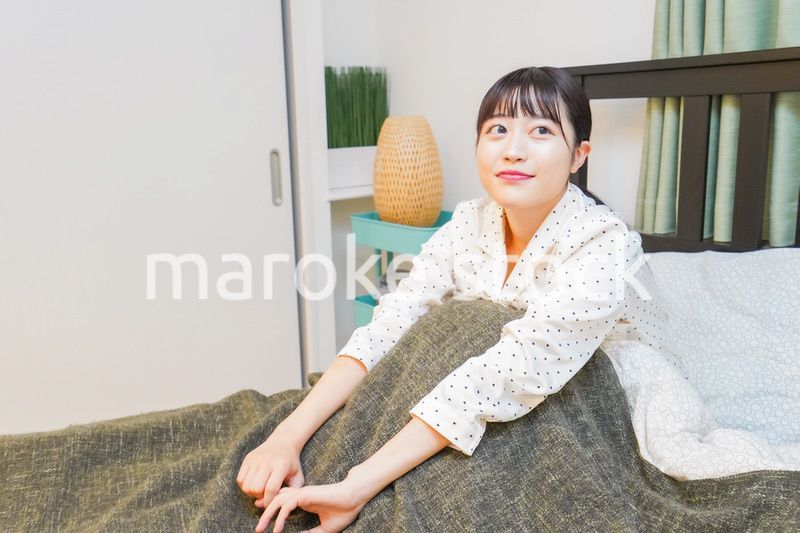 ベッドでリラックスをする若い女性