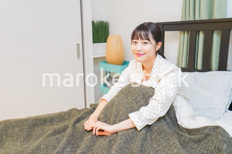 ベッドでリラックスをする若い女性