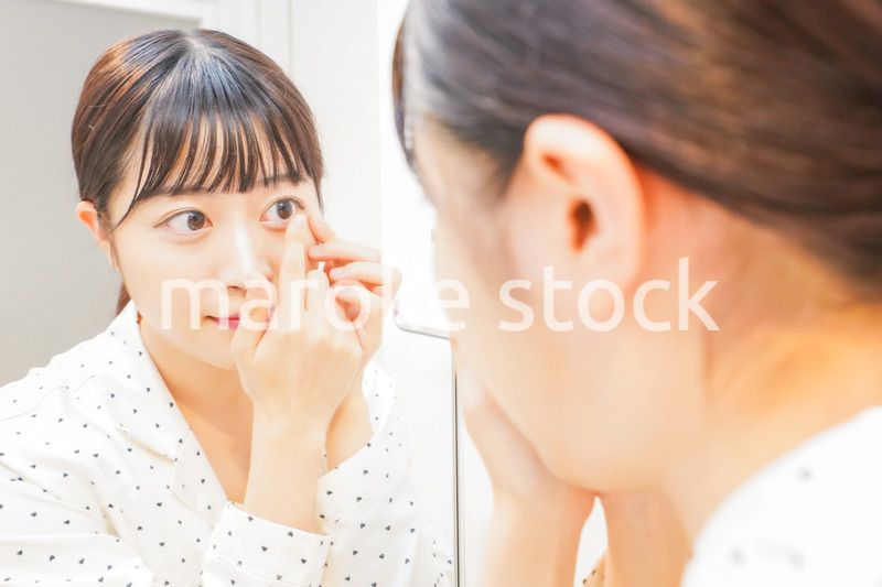 コンタクトレンズを装着する若い女性