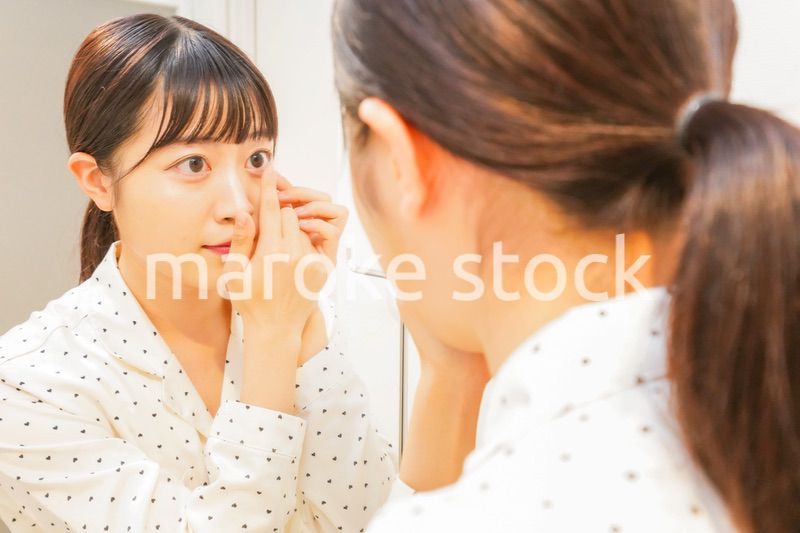 コンタクトレンズを装着する若い女性