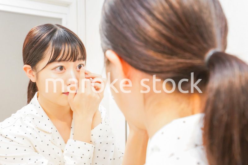 コンタクトレンズを装着する若い女性