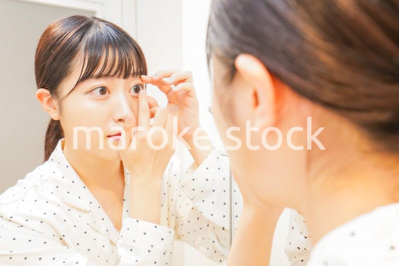 コンタクトレンズを装着する若い女性
