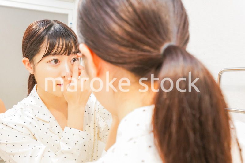 コンタクトレンズを装着する若い女性