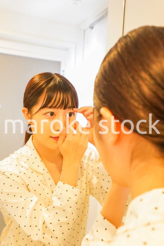 コンタクトレンズを装着する若い女性