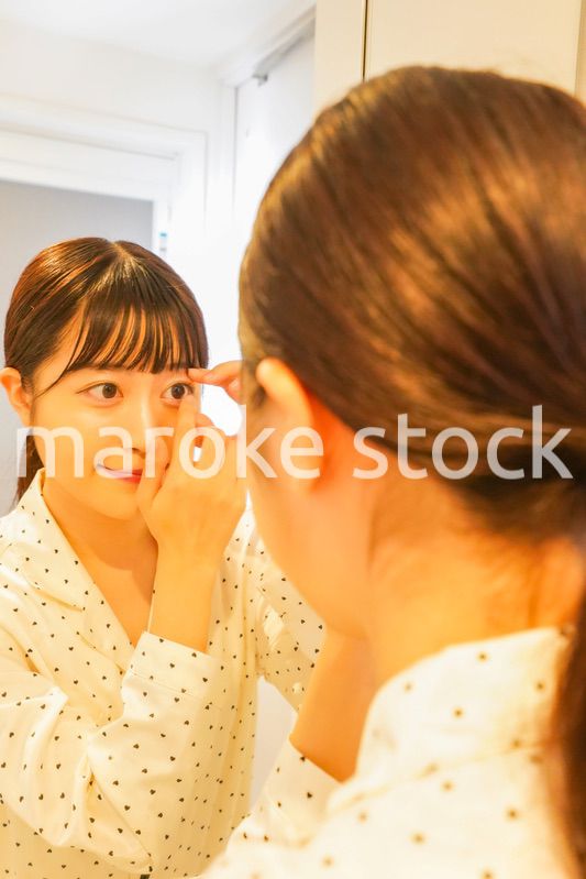 コンタクトレンズを装着する若い女性