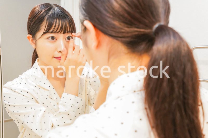 コンタクトレンズを装着する若い女性