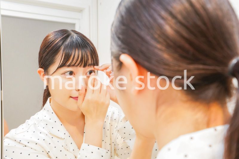 コンタクトレンズを装着する若い女性