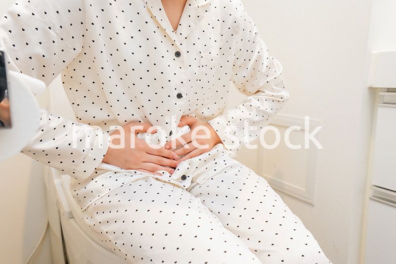 トイレで腹痛に苦しむ若い女性