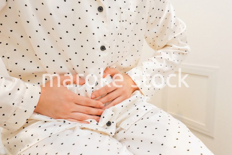 トイレで腹痛に苦しむ若い女性