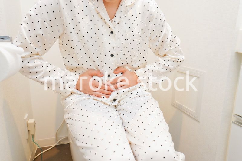 トイレで腹痛に苦しむ若い女性