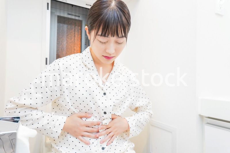 トイレで腹痛に苦しむ若い女性