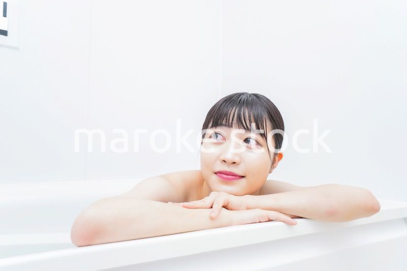 お風呂でお湯に浸かる若い女性