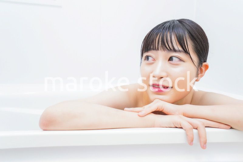 お風呂でお湯に浸かる若い女性