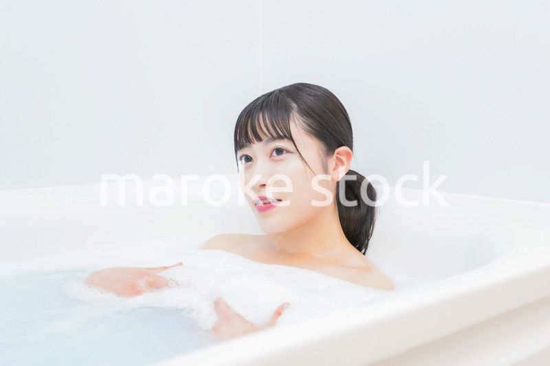 お風呂でお湯に浸かる若い女性