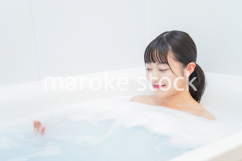 お風呂でお湯に浸かる若い女性